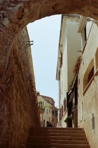 A narrow alleyway with stairs leading up to a building